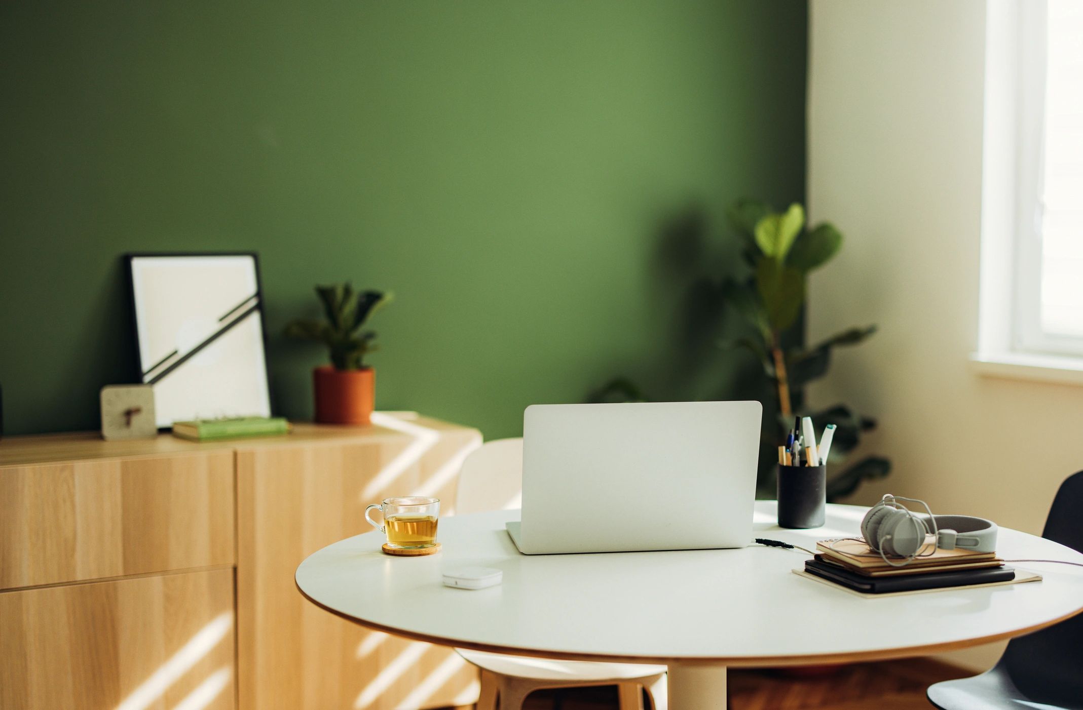 Minimal desk setup with notebook, pens, and a cup of tea
