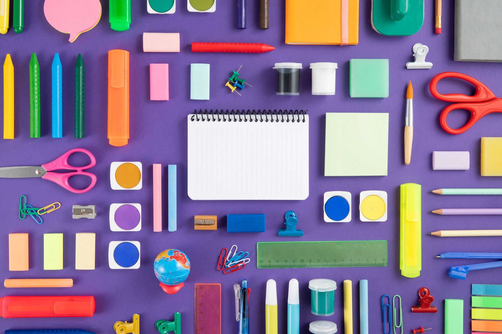 Colorful school supplies on a purple background